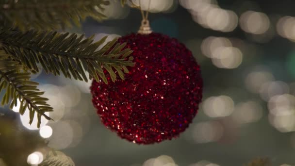 お祝いのパーティーでぼやけた夜の街灯にボールで飾られたクリスマスツリー — ストック動画