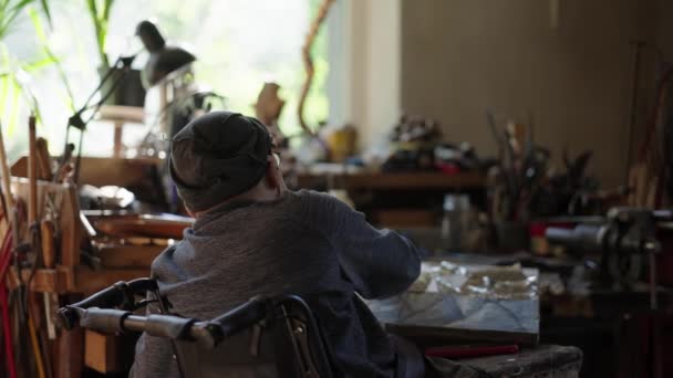 Senior Kunstenaar Een Rolstoel Brengt Zilver Aan Het Olieverfschilderij Doek — Stockvideo