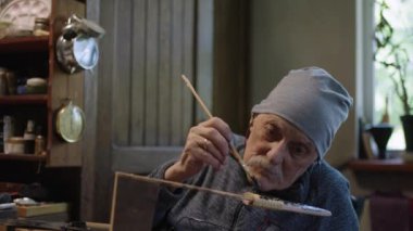 Yaşlı erkek üstat atölyesinde çalışıyor. Japon Deba bıçağını kılıfıyla restore ediyor.