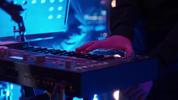 カラフルなステージ照明の下で電気ピアノを演奏する男性ミュージシャン — ストック動画
