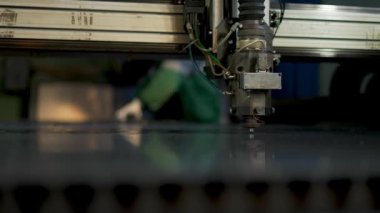 CNC lazer makinesinde çalışan teknisyen metal levha kesiyor