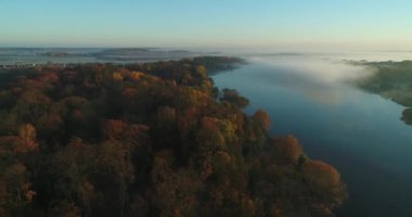 Gölün kıyısındaki parkta sisli sonbahar gündoğumu