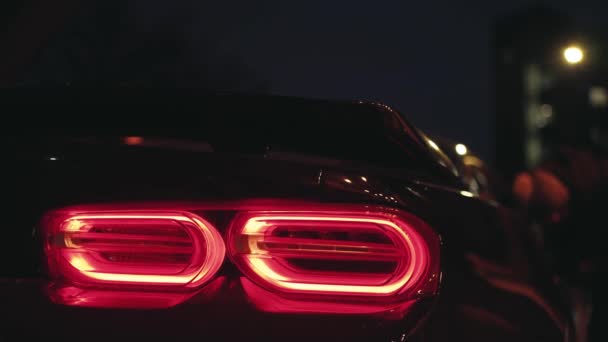 Schwarzes Sportwagen Rücklicht Leuchtet Dunkeln Einer Nächtlichen Stadt Blinkendes Standlicht — Stockvideo