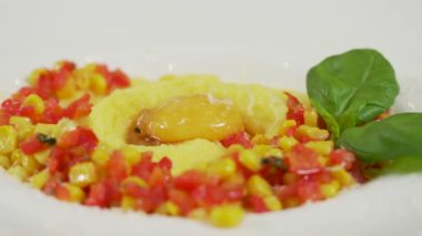 Millet, sebze soslu lapa ve yumurta sarısı tabakta servis ediliyor.