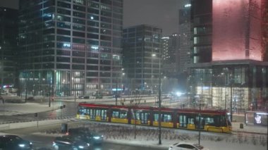 Modern tramvay Varşova 'daki modern binalarla ticaret bölgesinden geçiyor. Varşova, Polonya, 20 Aralık 2023