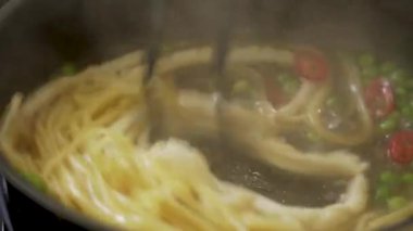 Şef kalamar fileto ve bezelyeli makarna yapıyor.