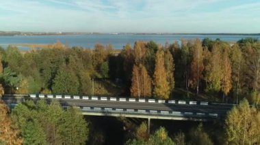 Güneşli bir yaz gününde, Avrupa kırsal kesiminde, geniş sularda akan yolun havadan görünüşü.