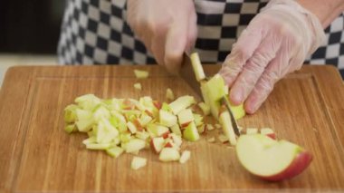 Şef olgun bir elmayı kesme tahtasında doğruyor.