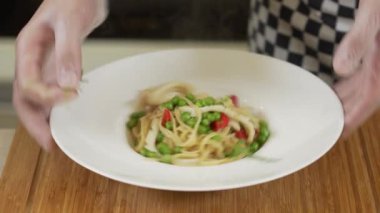 Şef kalamar fileto ve bezelyeli makarna linguini servis ediyor.