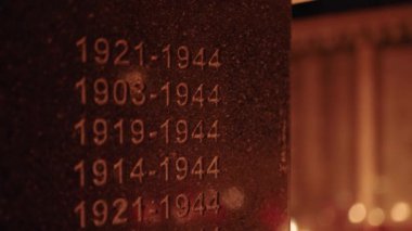 World war two monument tombstone lighted by the grave candles glowing on cemetery at night on All Saints Day