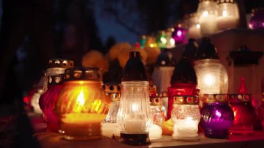 Azizler Günü bayramında gece mezarlıkta parlayan mumlar.