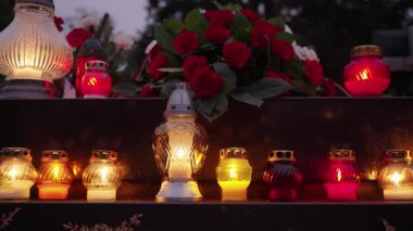 Azizler Günü bayramında gece mezarlıkta parlayan mumlar.