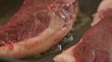 Şef tavada çiğ ördek göğsü kızartıyor.