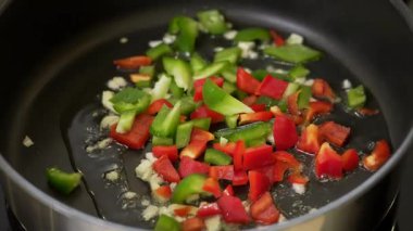 Şef sebze omleti pişirirken tavada doğranmış sebze kızartıyor.