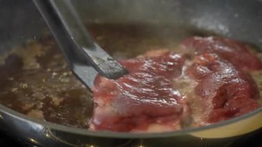 Şef tavada çiğ ördek göğsü kızartıyor.