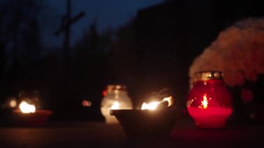 Azizler Günü bayramında gece mezarlıkta parlayan mumlar.