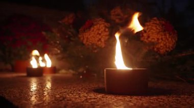 Azizler Günü bayramında gece mezarlıkta parlayan mumlar.
