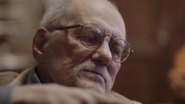 Tekerlekli sandalyedeki kıdemli yaşlı kuyumcu bir atölyede çalışıyor.