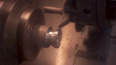 CNC değirmen makinesi çalışıyor. Atölyedeki cnc torna makinesini döndürmek için çelik metal işleme aracı kesiliyor
