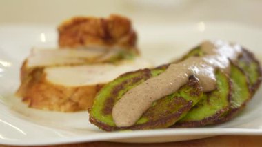 Ispanak ve kabaklı börek hindi filetosu ve hardal soslu krep tabakta servis ediliyor.