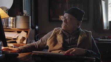 Kronik engelli yaşlı yetişkin tekerlekli sandalyede oturan bilgisayarla çalışıyor.