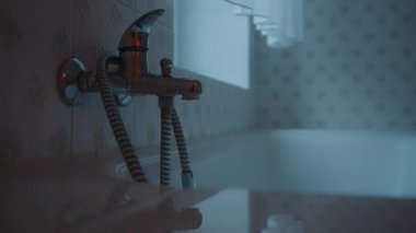 Banyodaki sızdıran musluktan su damlıyor.