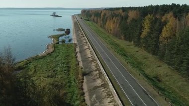 Güneşli bir yaz gününde, Avrupa kırsal kesiminde, geniş sularda akan yolun havadan görünüşü.