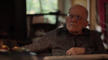 Kronik engelli yaşlı yetişkin tekerlekli sandalyede oturan bilgisayarla çalışıyor.