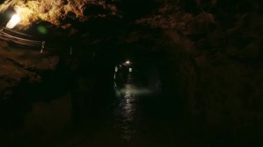 Exploring touristic attraction of a dark cave with an underground tunnel