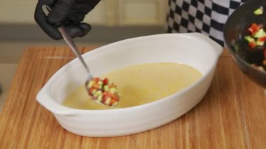 Şef sebzeli omleti fırında pişirmek için hazırlıyor.