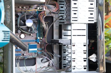 Cleaning a dusty computer with a blower.