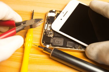 Top view of a technician repairing a smartphone