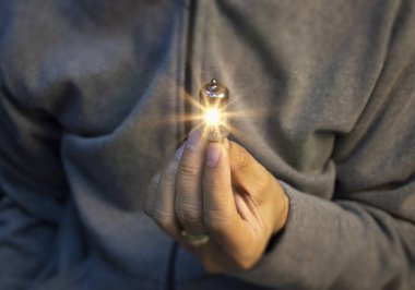 İnsan el ele tutuşması ampul, fikir, yenilik ve ilham parlayan sanal beyin, akıllı yaratıcılık ampul, motivasyon ve yenilik kavramı