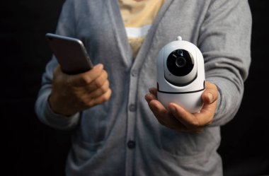 Beyaz IP kamerası tutan kadın. Güvenlik nedeniyle çok popüler..