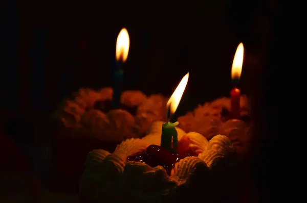 キャンドルライトと誕生日ケーキの画像 — ストック写真