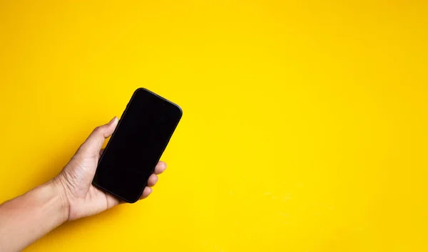 Mano Sosteniendo Smartphone Sobre Fondo Amarillo —  Fotos de Stock