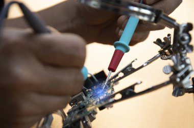 Teknisyenler anakartları tamir ediyor, elektrik akımlarını kontrol ediyor, devreleri onarıyor.