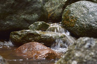 Kayaların üzerinden akan bir şelale görüntüsü.