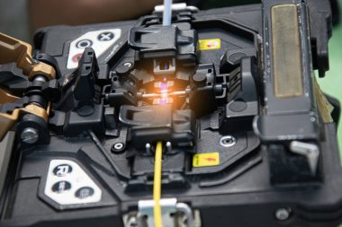 Teknisyen fiber optik kabloyu bir araçla bağlıyor..
