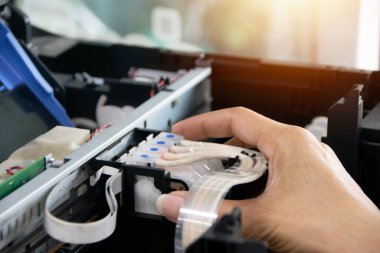 Teknisyen baskı başını hizalayıp yazıcıyı tamir ediyor..
