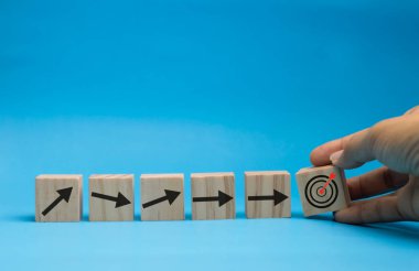 Hedefe doğru fırlatılan oklarla tahta bloklar kavramı.