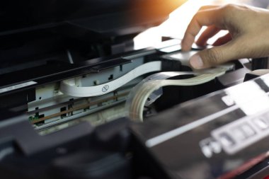 Yazıcıyı denetleyen ve tamir eden teknisyenlerin yan görünümü.