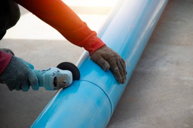 İşçiler PVC boru kesme araçları kullanıyor.