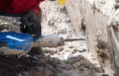 İşçiler beton çekiç matkabı kullanıyor..