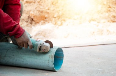 İşçiler PVC boru kesme araçları kullanıyor.