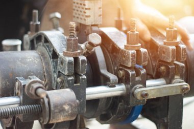 Tesisatçılar büyük su borularını bağlamak için araçlar kullanırlar.