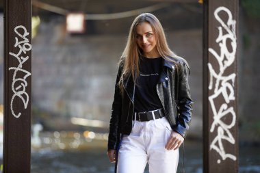 Sokakta poz veren deri ceketli güzel bir kadın.