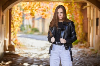 Sokakta poz veren deri ceketli güzel bir kadın.