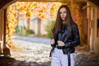 Sokakta poz veren deri ceketli güzel bir kadın.
