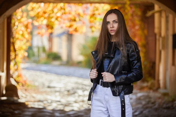 Sokakta poz veren deri ceketli güzel bir kadın.